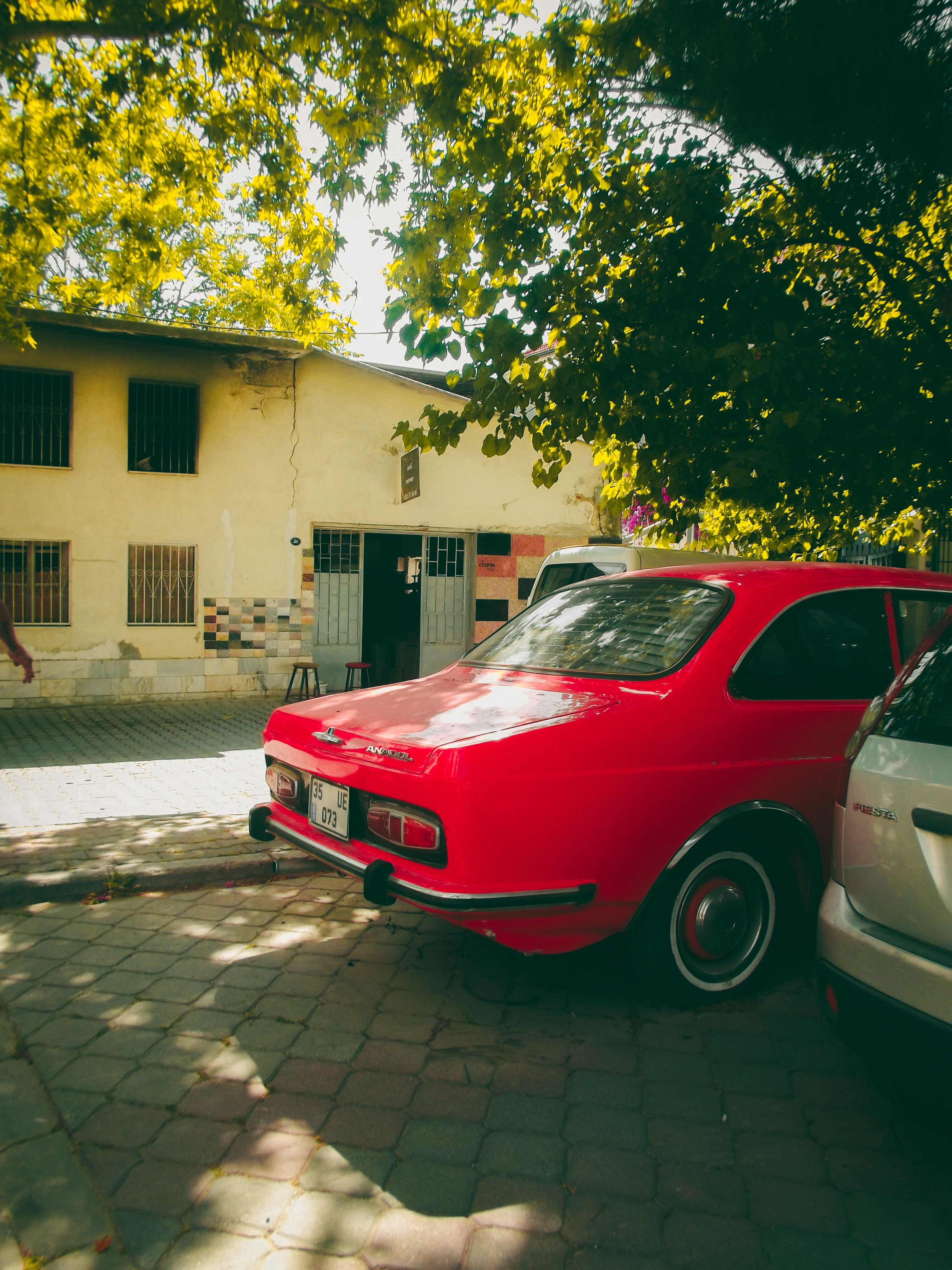A red car parked on the side of the road · Free Stock Photo