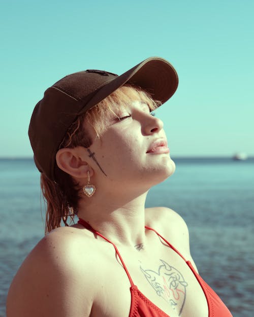 A woman in a red bikini and a baseball cap