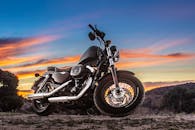 捕捉在土路上骑摩托车于日落时分的自由