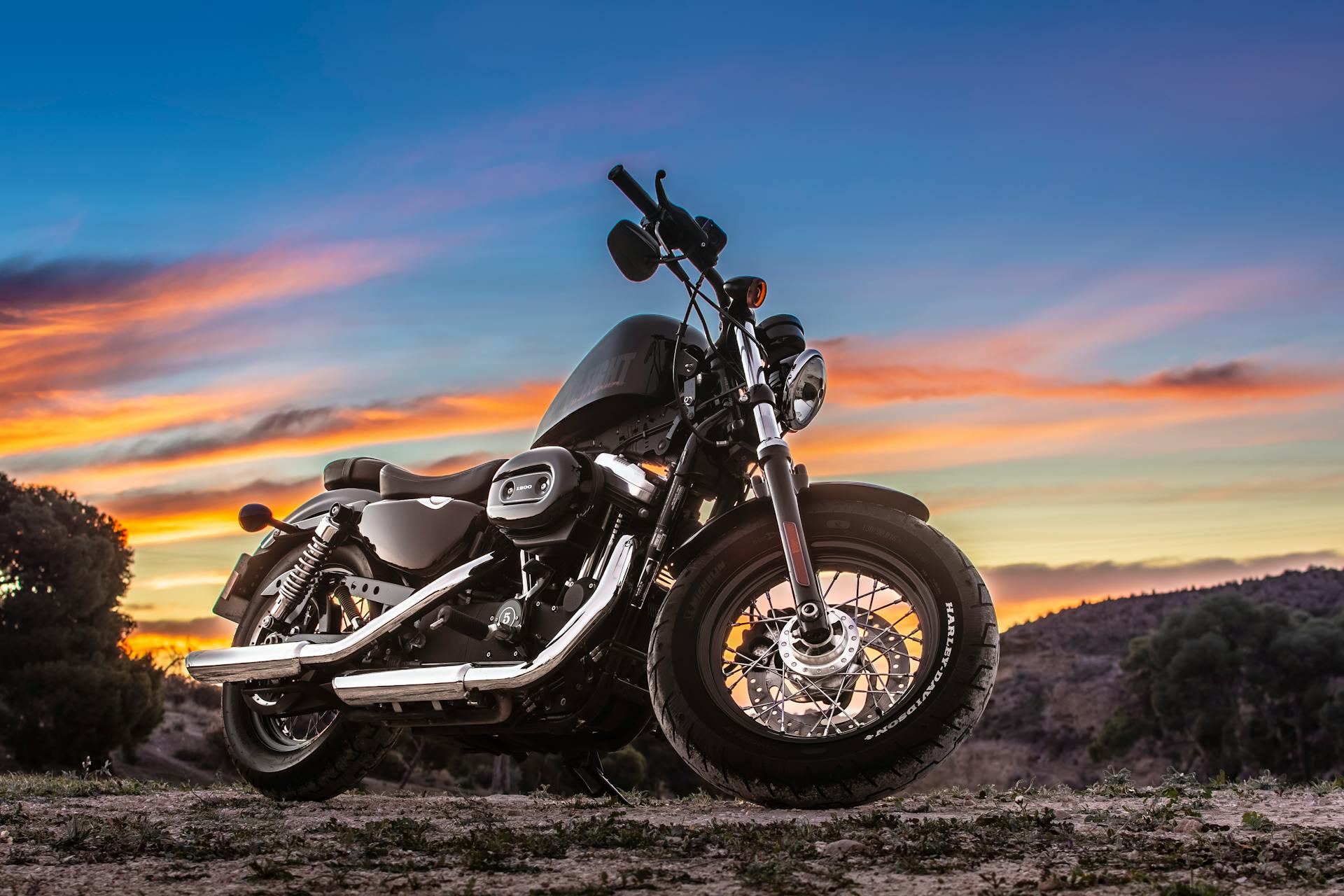 Capture the freedom of riding a motorcycle at sunset on a dirt road.