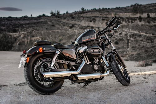 Gratis Foto Black Harley Davidson Forty Eight 1200 Sepeda Motor Yang Diparkir Di Jalan Kerikil Foto Stok