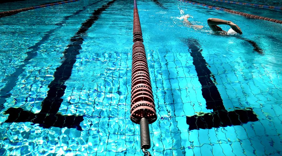 Bassin de natation illustrant les précautions à prendre avec ses bijoux avant les sports aquatiques