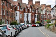 Photo of Vehicles on Road Near Houses