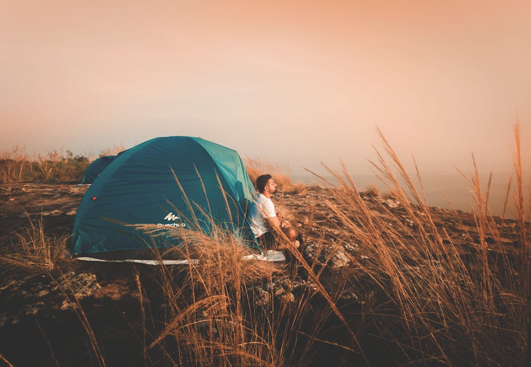 Free Photo of a Man Sitting Outside the Tent Stock Photo