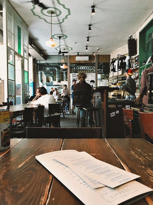 People Sitting on Bar Chairs and Dining Chairs