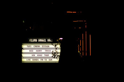 A sign with the words, the theater, and a clock