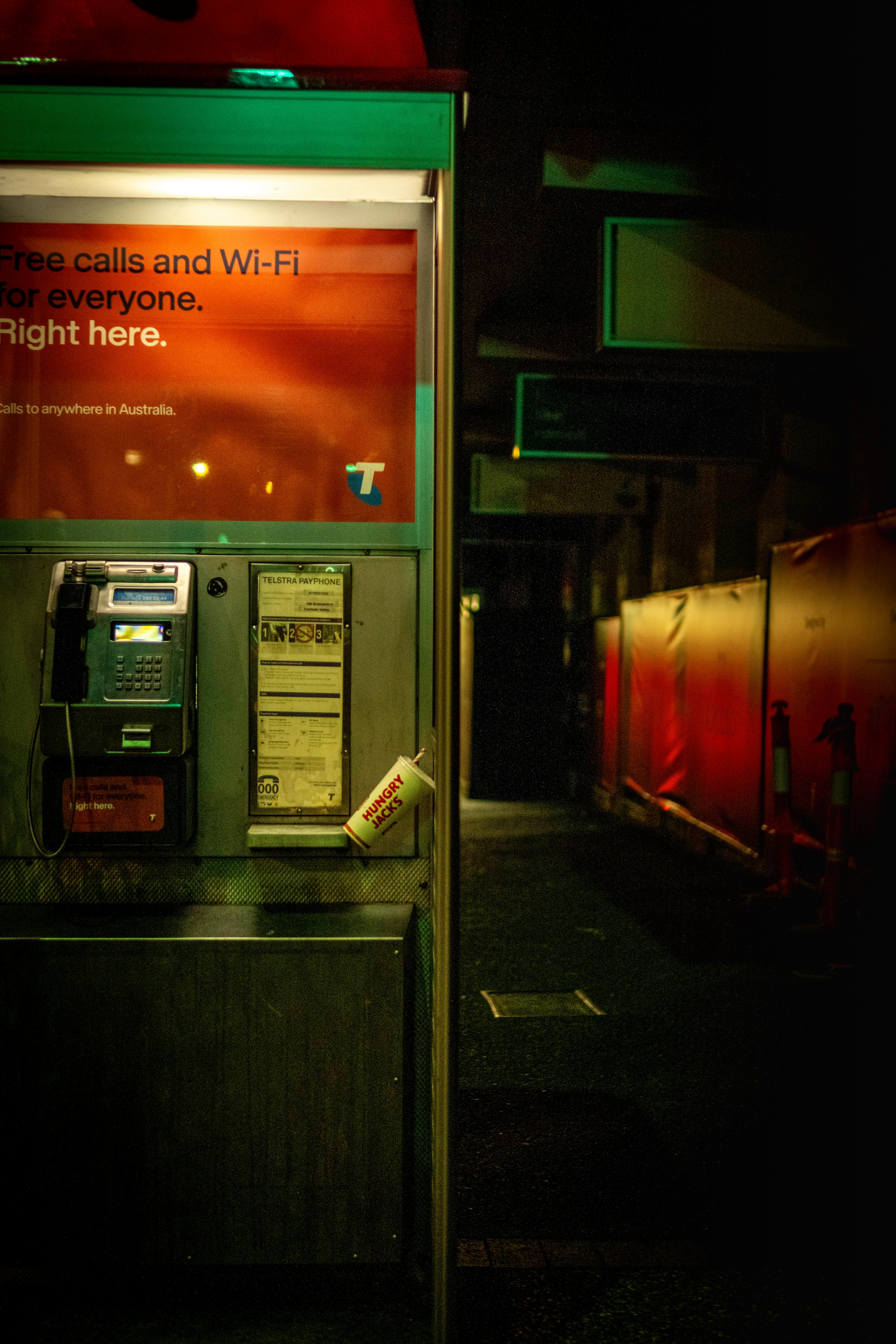 a pay phone in a dark alley at night