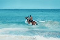 一名男子在哥伦比亚圣安德烈斯附近的碧绿水域中骑马