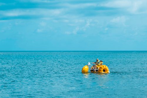 Free A couple pedaling a yellow water bike on the clear blue sea of San Andrés, Colombia. Stock Photo