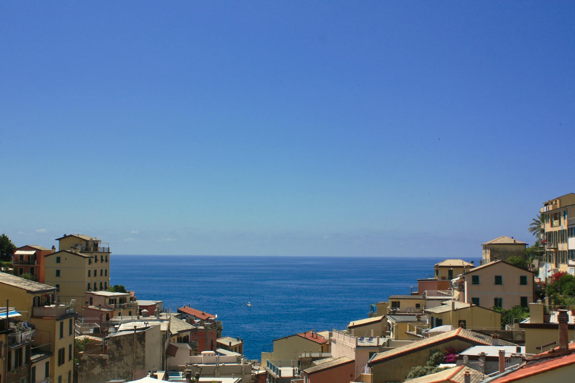 Discover the stunning coastal town of Riomaggiore, featuring vibrant buildings and the azure Ligurian Sea.