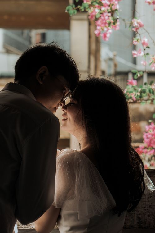 Free A loving couple sharing a heartfelt, romantic moment near blossoming flowers. Stock Photo