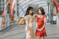两个年轻女子穿着夏季服装站在桥上
