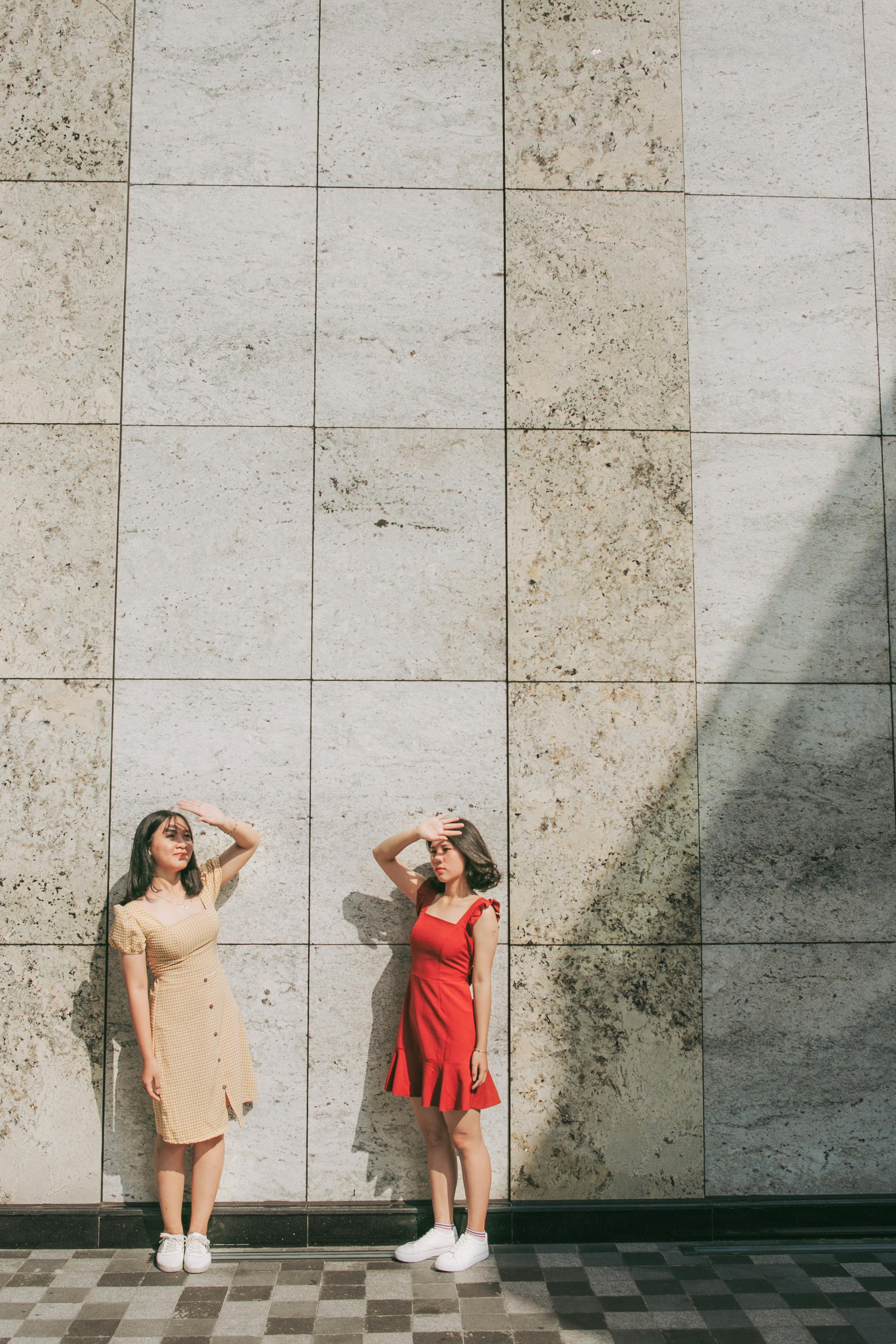 两名妇女站在石瓦墙上遮挡阳光