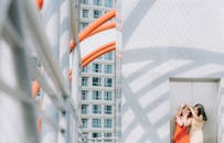 在现代城市建筑环境中，两名女子正享受着阳光明媚的一天