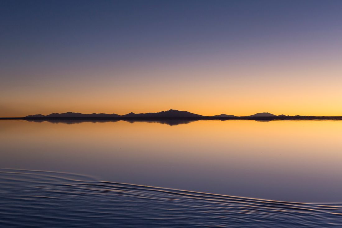 Sunrise mirrored on a flooded salt flat — photo by Leonardo Rossatti on Pexels