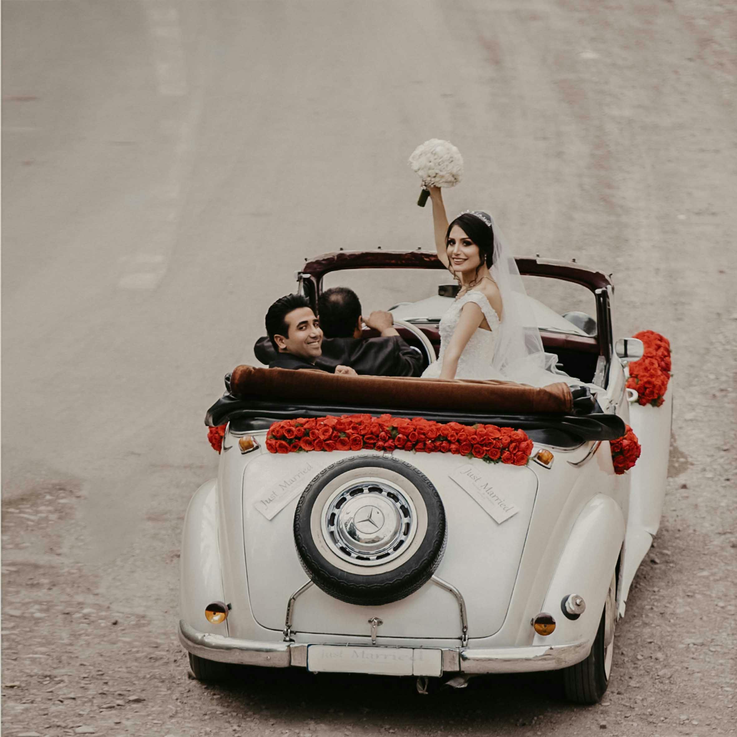groom and bride riding on white vehicle