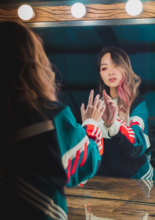 Back View Photo of Woman Posing In Front of Vanity Mirror