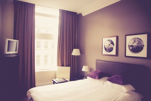 Free Vintage style bedroom with natural light and cozy decor. Stock Photo