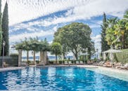 在豪华的热带度假村池畔，棕榈环绕，碧空如洗，享受宁静的一天