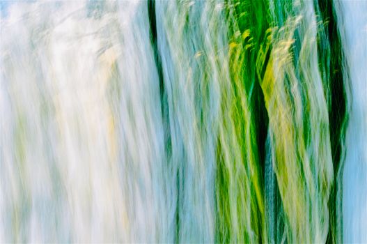 Abstract depiction of flowing water with vibrant green and blue hues creating a dreamy texture.