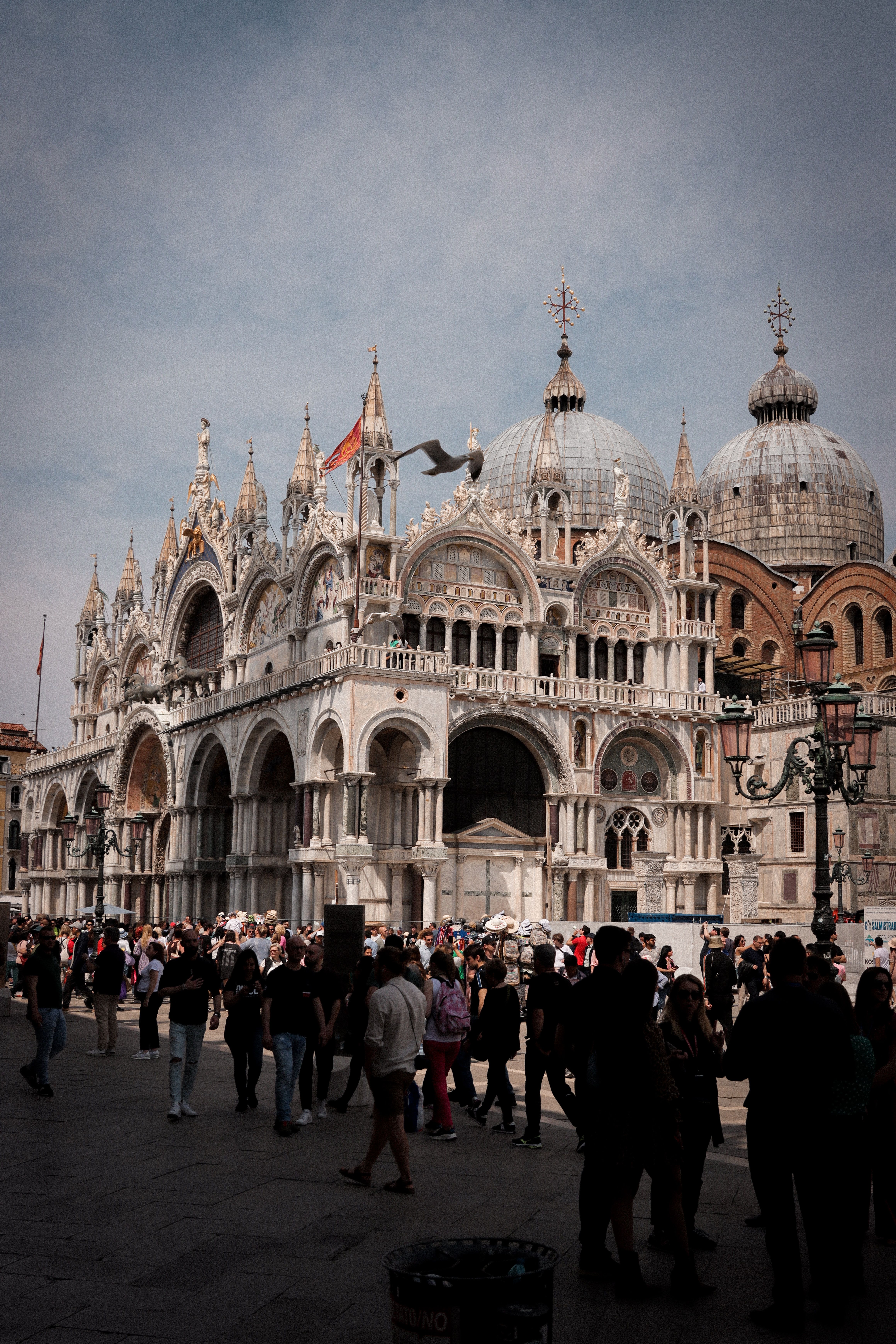 Stunning view of St. Mark's Basilica in Venice with tourists exploring the Venetian architecture.