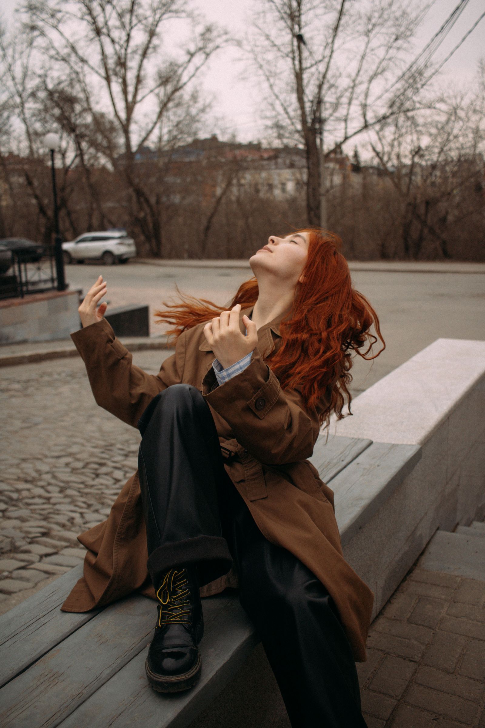 A Woman in Brown Trench Coat Sitting on the Ledge · Free Stock Photo