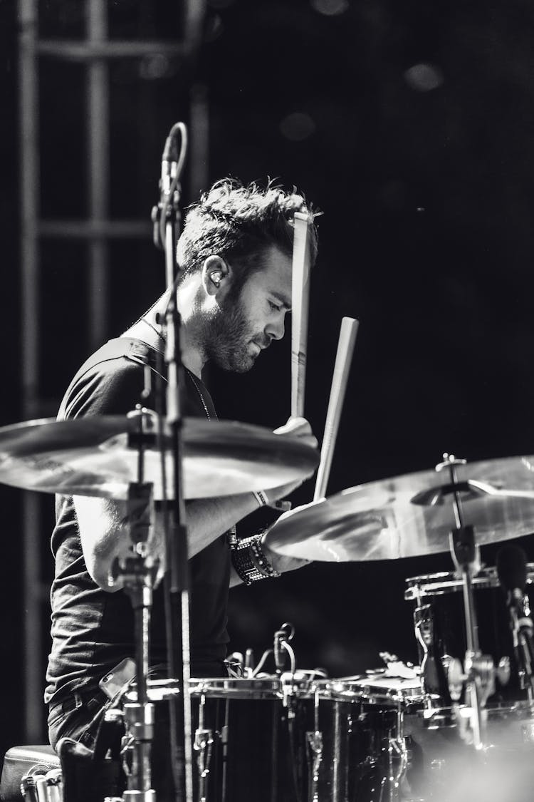 Grayscale Photo Of A Man Playing Drums