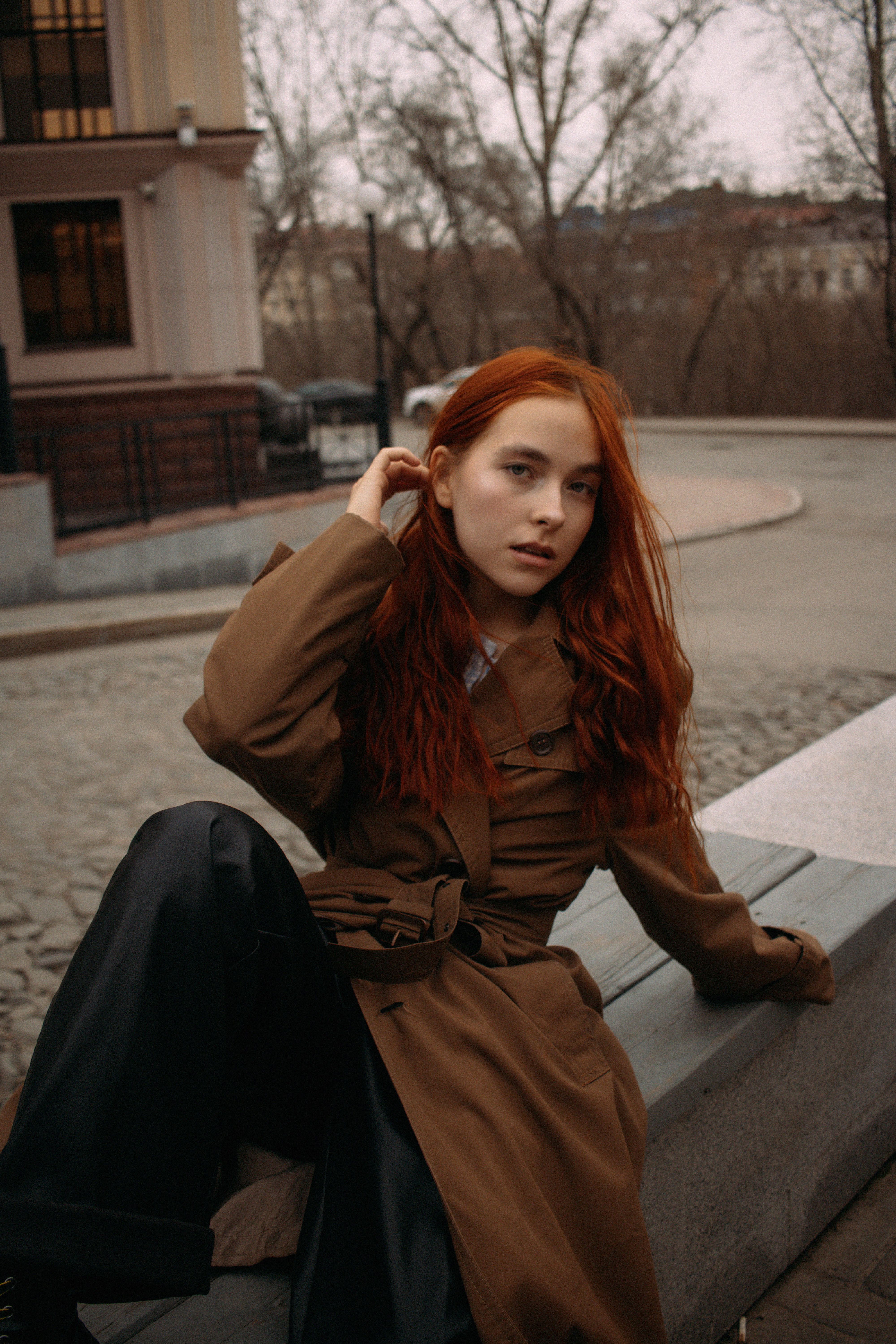 Redhead woman in autumn fashion posing outdoors in urban setting, Tomsk, Russia.
