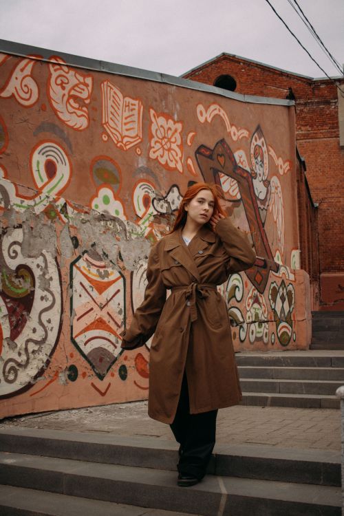 Free Woman in trench coat posing near colorful graffiti in Tomsk, Russia Stock Photo
