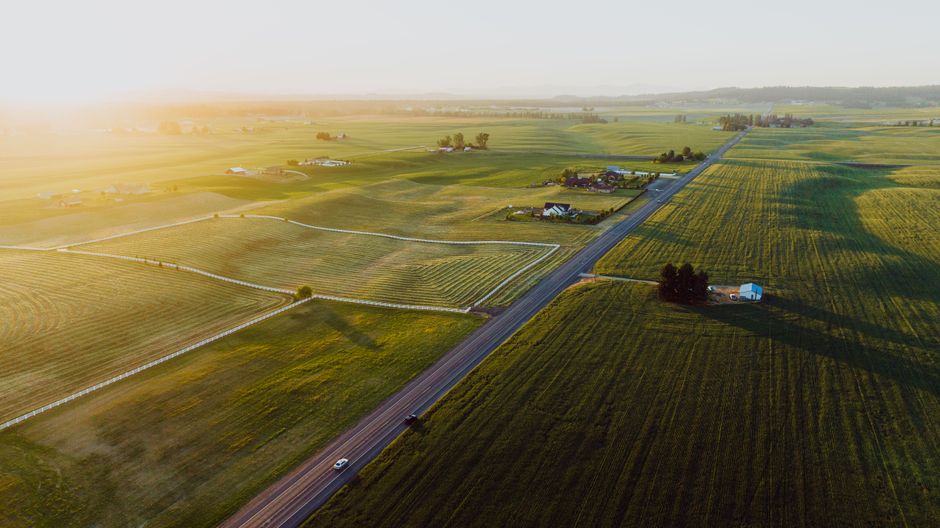 A picturesque aerial view of serene farmland near Spokane, WA, under the glow of sunrise.