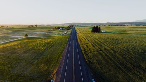 Free A stunning aerial view of a rural road cutting through lush green fields in Spokane, WA at sunrise. Stock Photo