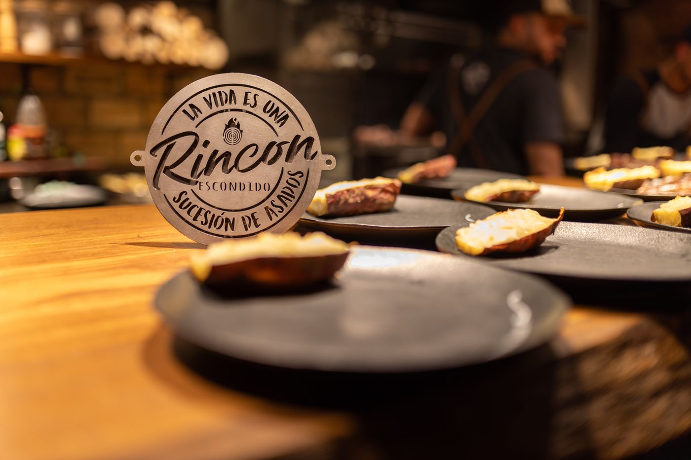 Close-up of artistic dishes with gourmet food in a warmly lit restaurant setting.