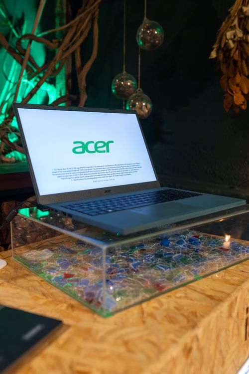 Free A sleek Acer laptop is showcased on a glass stand with colorful accents in a stylish indoor setup. Stock Photo