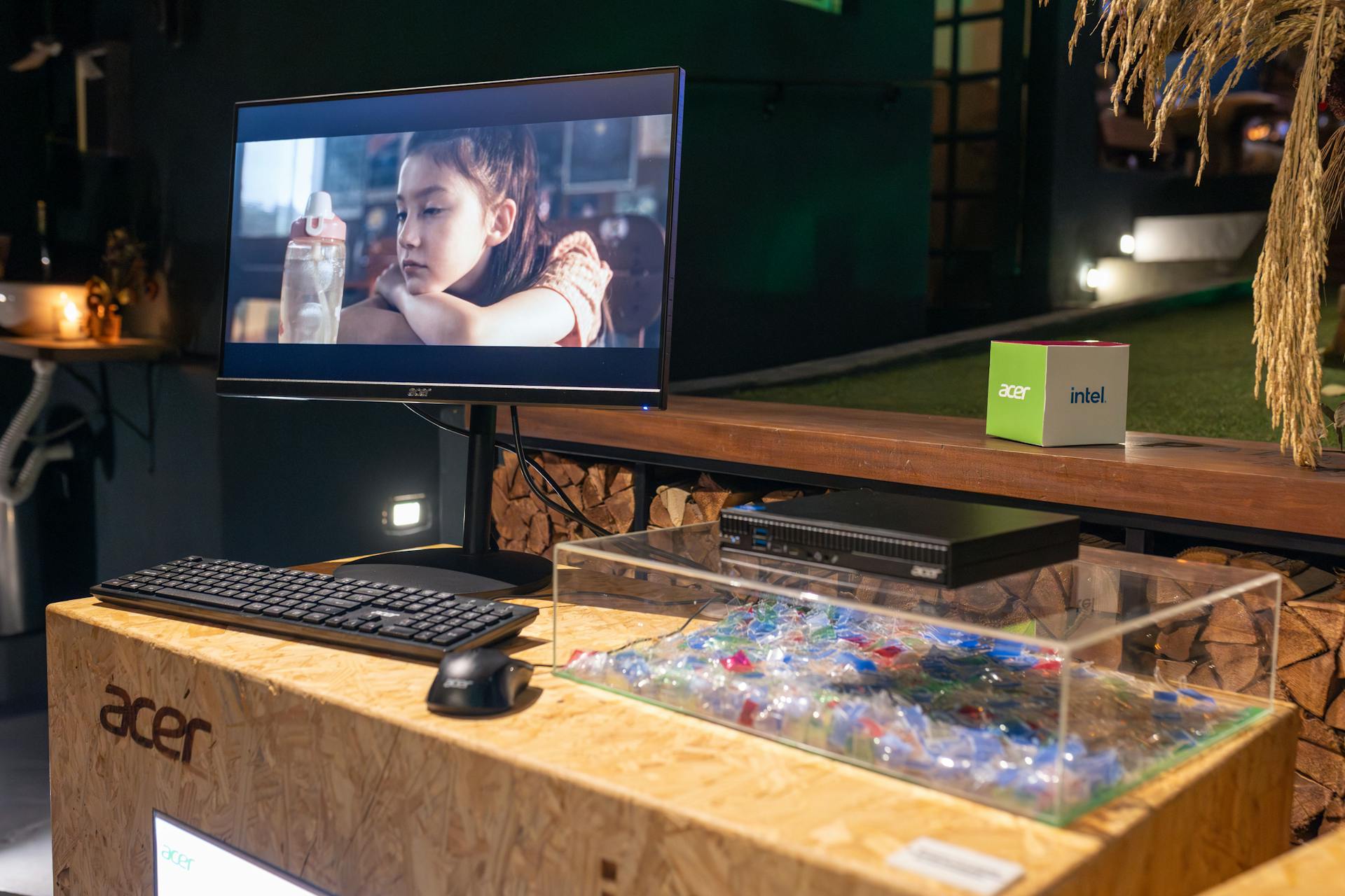 A sleek computer setup featuring an Acer monitor and peripherals at an indoor exhibition.