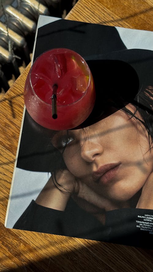 A magazine with a drink on it and a hat