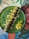 Delicious sushi roll on a green plate with sauce and garnish, styled on a retro magazine.