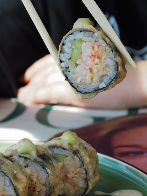 Free A delectable sushi roll held by chopsticks, showcasing fresh ingredients in a close-up shot. Stock Photo