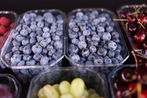 Fresh blueberries and grapes in plastic containers