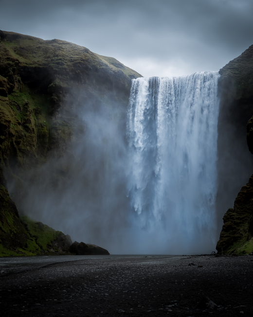Captivating view of Skogafoss waterfall cascading amidst Iceland's lush landscape.