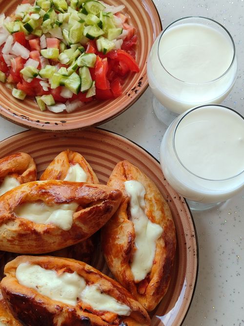 Free Top view of Turkish pides with cheese, fresh salad, and drinks. Perfect breakfast spread. Stock Photo