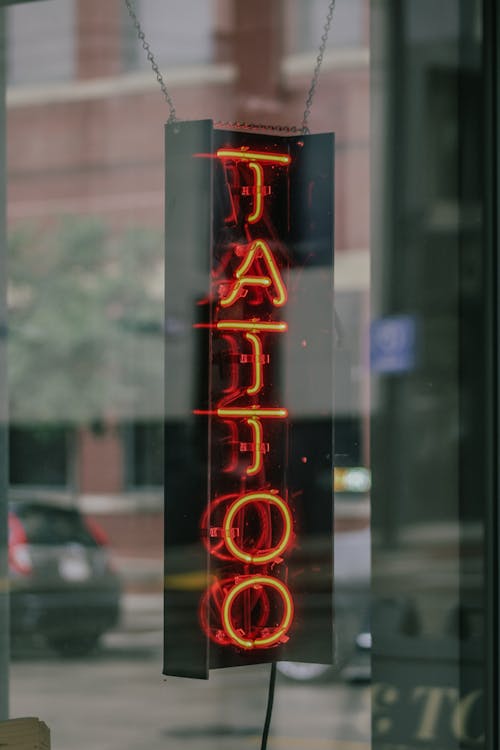 A neon sign that says tattoo on it