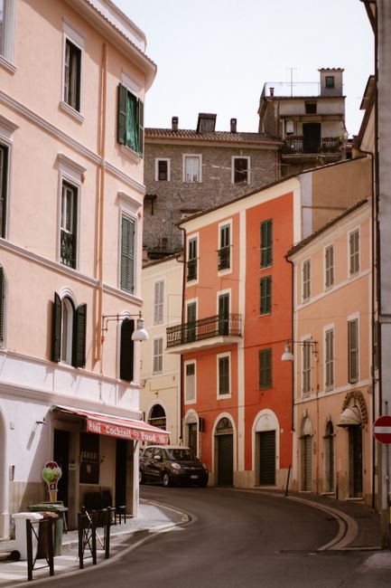 A picturesque narrow street in Italy featuring colorful building facades and urban charm.