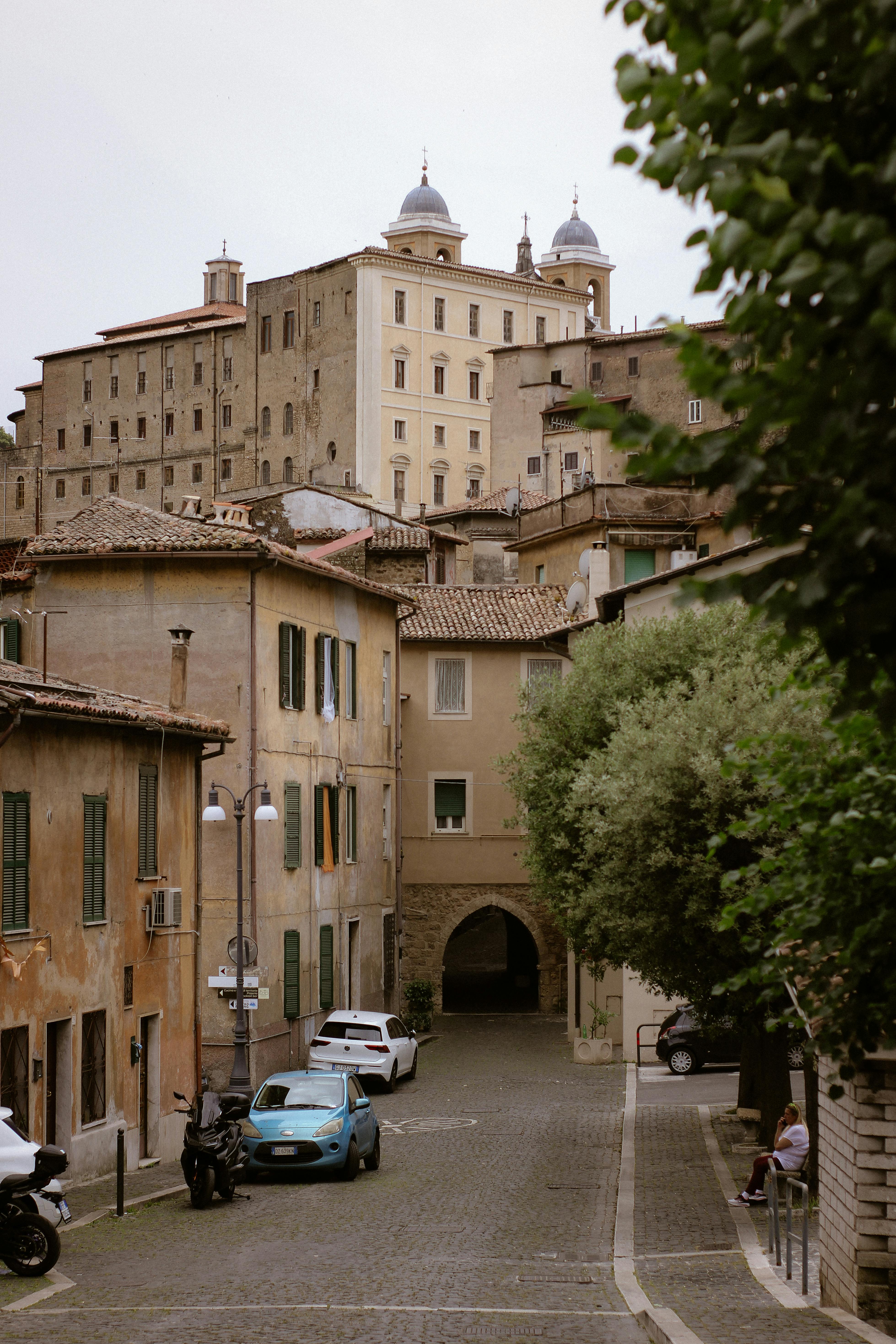 Peaceful cobblestone street view in an old town with historic buildings and archways.