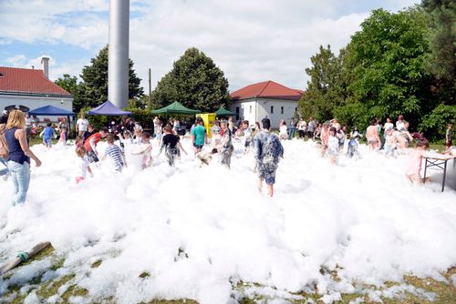 Free Lively foam party outdoors with children and families playing under the sun. Stock Photo