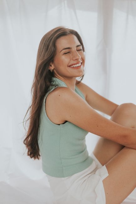 A smiling woman with long hair posing indoors with a serene expression.