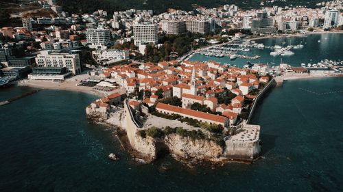 Free Explore the stunning aerial view of Budva's historic old town with its red-tiled roofs and scenic Adriatic coastline. Stock Photo