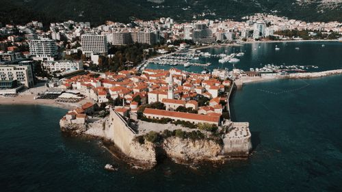 Free Stunning aerial view of Budva's historical old town, turquoise sea, and modern skyline. Stock Photo