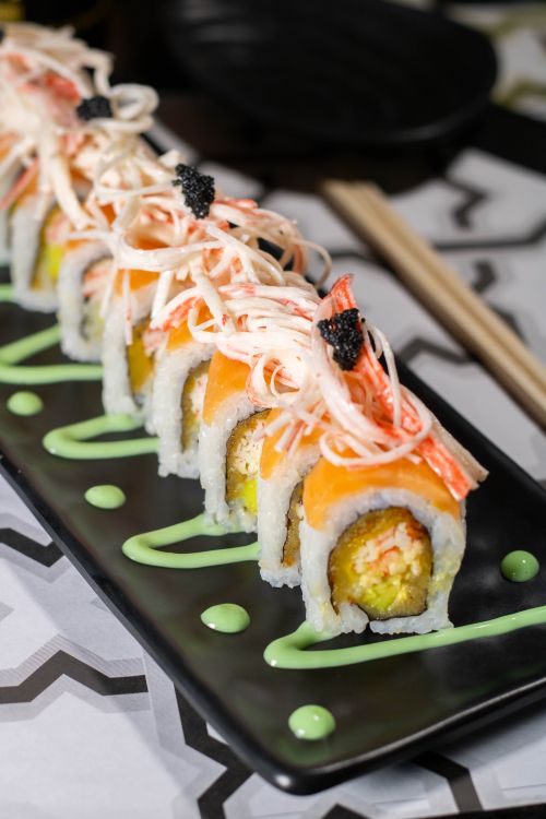 Free Close-up of gourmet sushi rolls topped with crab and caviar on a decorative plate. Stock Photo