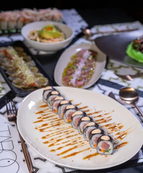 Exquisite selection of sushi with sauces in a fine dining setup, perfect for culinary photography.