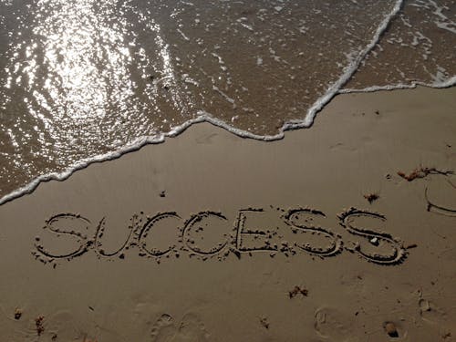 Success Text Write on Beach Shore